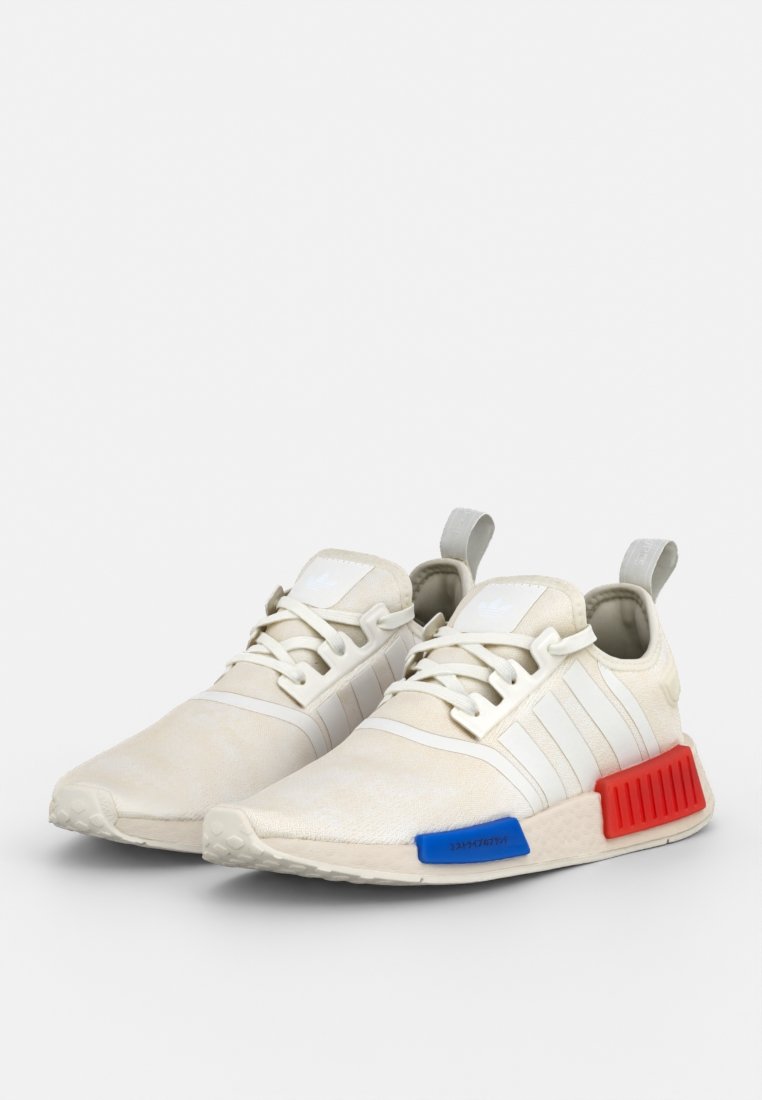 Weiße Sneaker aus strukturiertem Material, mit drei weißen Streifen, einem blauen Akzent auf dem linken Schuh und einem roten Akzent an der rechten Ferse.