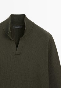 Maglione a costine verde oliva scuro con colletto a polo a forma di V e maniche lunghe, con dettagli visibili sulla parte superiore frontale e sul colletto.