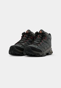 Hiking shoes in black and gray with red accents. Features a textured mesh upper, robust rubber outsole, and lacing system for secure fit.