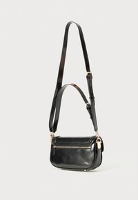 Black leather crossbody bag with a rectangular shape, adjustable strap, gold-colored hardware, and a zippered compartment on the front.
