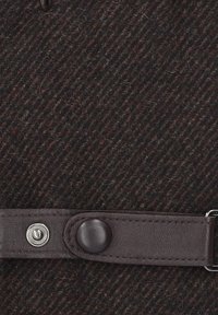 Brązowa tkanina pleciona z ukośnymi paskami, akcentowana ciemnym skórzanym paskiem z zatrzaskiem i gładką teksturą.