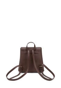Sac à dos en cuir marron avec une finition texturée, double bretelles et une poignée sur le dessus. Design simple avec un accent matériel minimal.