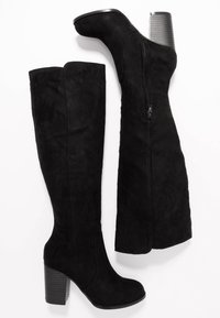 Czarne kozaki za kolano wykonane z ekologicznego zamszu, z bocznym zamkiem, masywnym słupkowym obcasem i gładką fakturą bez widocznych wzorów.