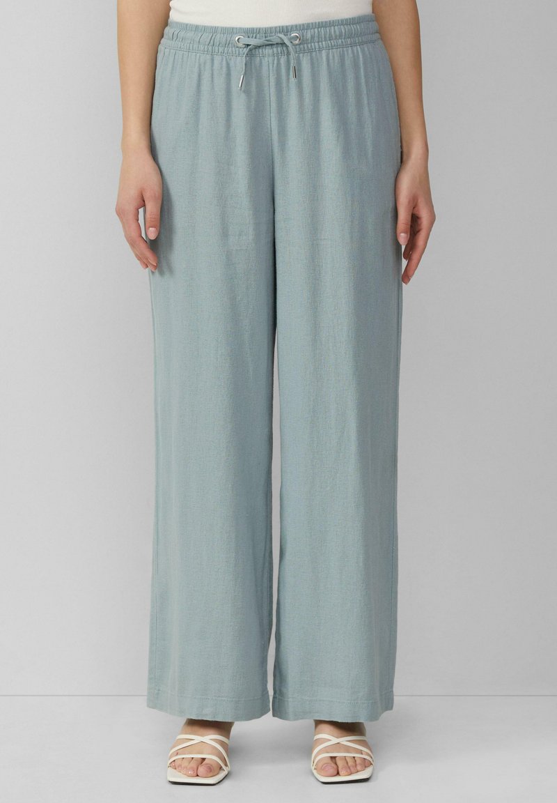 Pantalons larges de couleur bleu clair, fabriqués à partir d'un matériau doux, avec une taille élastique et un cordon de serrage. Pas de motifs visibles ni de poches.