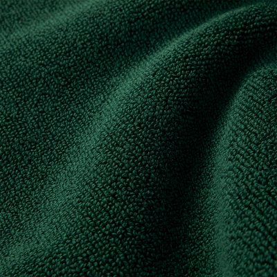 Υφασμα σε πράσινο χρώμα με υφή, υφασμένο με λουπωτό μοτίβο, που δείχνει μια απαλή, αφράτη επιφάνεια με βαθύ χρώμα και διακριτική γυαλάδα.