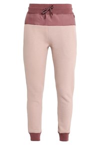 Ljusrosa sweatpants med bordeaux elastisk midja och mudd. Har en slät överdel och texturerad tyg på kroppen.