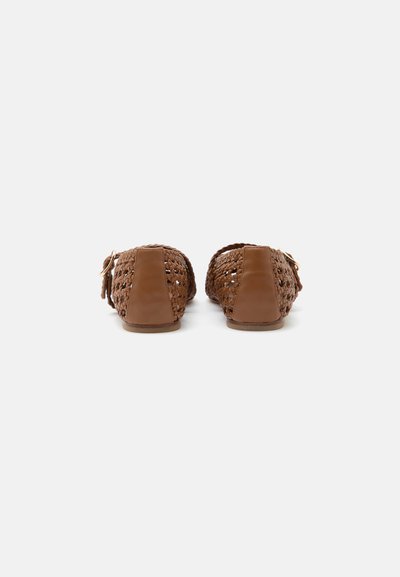 Chaussures plates tissées marron avec talons fermés et petites boucles, vues de dos sur fond blanc.