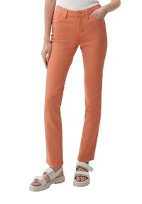 Pomarańczowe spodnie z bawełny w składzie mieszanym, o prostym kroju nogawki, z przednią kieszenią i zapięciem na guzik. Połączone z białymi sandałami.