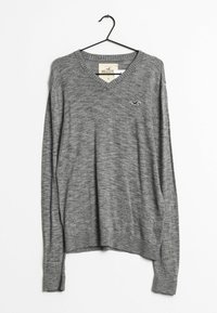 Grå v-ringad tröja gjord av mjukt stickat material. Har långa ärmar och ribbad nederkant. Liten logotypdetalj på vänster bröst.