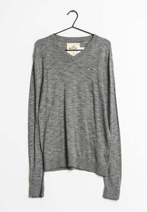 Maglione grigio a collo a V realizzato in morbido tessuto a maglia. Caratterizzato da maniche lunghe e orlo a costine. Piccolo logo nella parte sinistra del petto.