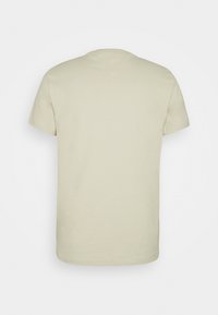 Plain light beige short-sleeve t-shirt shown from the back with simple stitching around the collar and sleeves.