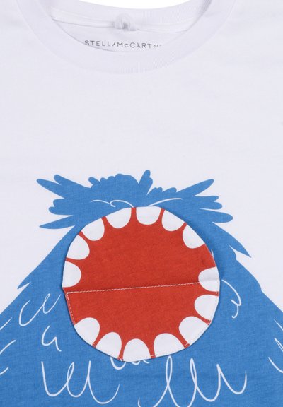 Biała koszulka z niebieskim wzorem potwora oraz szczegółem czerwonego, przypominającego ząb ust. Wykonana z miękkiego bawełnianego materiału z przeszyciami i zabawnymi kształtami.