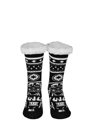 Schwarz-weiß gemusterte kuschelige Socken mit weißen, flauschigen Bündchen, mit Schneeflocken- und geometrischen Mustern.