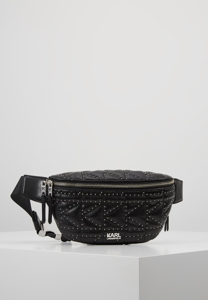 Mustavalmennettu nahkavyölaukku, jossa on hopeiset niitit, kaksi vetoketjun vetotankoa, säätöremmi ja "KARL LAGERFELD" -logo edessä.