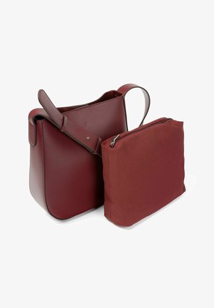 Sac en cuir bordeaux de forme seau avec une pochette en toile bordeaux amovible, présentant une forme incurvée, une base plate et une courte poignée.