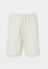 Pantalones cortos beige claro hechos de tela texturizada, con una cintura ajustable mediante cordón y un diseño a la altura de la rodilla con sutiles rayas verticales.