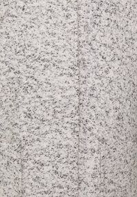 Světle šedá texturovaná látka s tkaným vzorem, obsahující černé tečky. Povrch je měkký s mírně chlupatým vzhledem a bez viditelného kování.