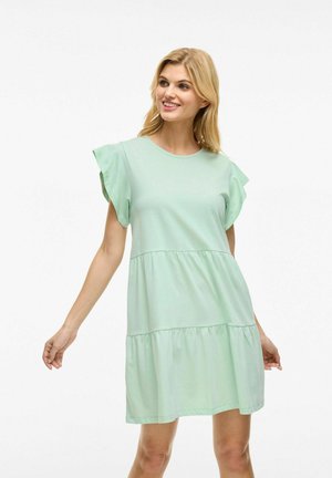 Vestido de manga corta verde claro con cuello redondo, mangas con volantes y un diseño de falda con volantes. Hecho de una tela suave y ligera.