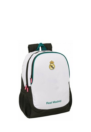 Plecak z białym przodem, czarnymi bokami, logo i napis Real Madrid, dwoma zamykanymi na zamek komorami oraz siateczkowymi kieszeniami po bokach.