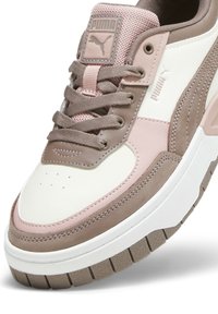 PUMA-sneakers med en beige och rosa färgschema, i mocka och läder, rundad tå, tjock vit sula och framträdande logotypdetalj.