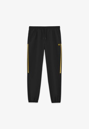 Pantaloni jogging neri con vita e polsini elastici, caratterizzati da strisce gialle laterali e un piccolo logo giallo di un'aquila sulla coscia destra.