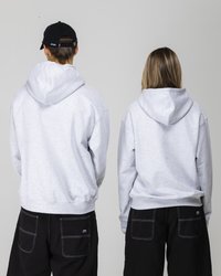 Graue Kapuzenpullis mit Kordelzug, die eine lockere Passform aufweisen. Getragen mit schwarzen Hosen, die kontrastierende Nähte und Gesäßtaschen zeigen.