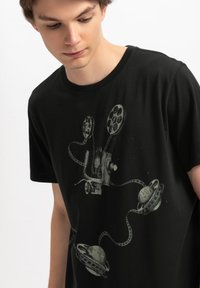 Zwarte katoen T-shirt met een grafische print van filmrollen en planeten, in een mix van grijs en witte tinten. Regular fit, korte mouwen.