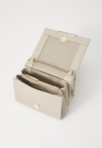 Beige keinon nahkakäsivarrellinen laukku, jossa on avoin yläosa, kultaiset varusteet, ketjuhihna, useita lokeroita ja vetoketjullinen sisätasku.