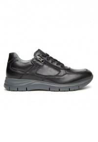 Zapatilla de cuero negra con suela gris, que presenta un cierre con cremallera y un diseño de cordones. Textura suave con detalles de costura sutiles.