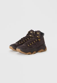 Black suede high-top sneakers with gold hooks and laces, featuring a textured rubber sole and smooth black accents.