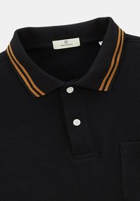 Polo noir en tissu texturé, avec deux boutons blancs et un col présentant deux rayures orange de chaque côté.