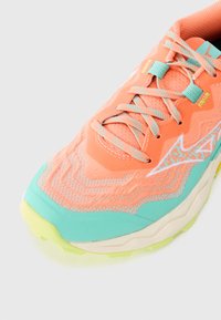 Sportschoen met een textuur van koraal bovenwerk, turquoise accenten en een lichtgele zool; heeft complexe stiksels en stijlvolle veters.