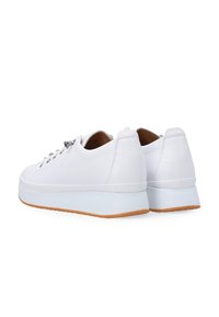 Hvide lædersneakers med et minimalistisk design, der har en hævet gummisål og en glat tekstur. Snørresystemet er synligt foran.