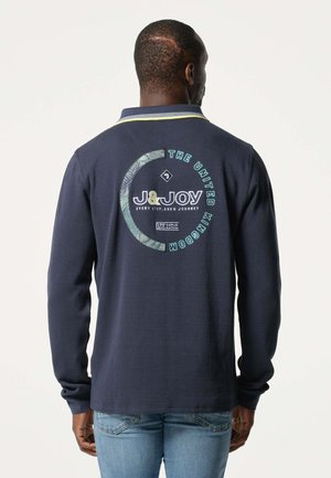 Polo à manches longues bleu marine avec un logo graphique vert et du texte au dos. Il présente un col plat et des détails de couture contrastants en jaune.