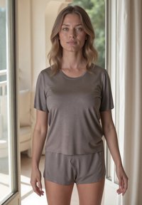 Top gris de manga corta y pantalones cortos a juego en una tela suave y lisa, con un corte relajado y escote redondo, exhibidos en un interior bien iluminado.