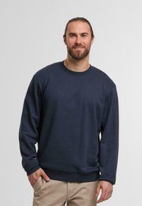 Sweatshirt bleu marine à manches longues et col rond, fabriqué en matériau doux. Présente des poignets et un ourlet côtelés, avec une coupe décontractée.