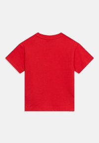 Κόκκινο μπλουζάκι με κοντά μανίκια και στρογγυλή λαιμόκοψη, με μονόχρωμη πίσω πλευρά, απλωμένο επίπεδα σε λευκό φόντο.