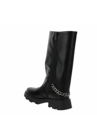 Bota de cuero negra a media pantorrilla con suela gruesa, cremallera lateral y detalle decorativo de cadena plateada en el talón trasero.
