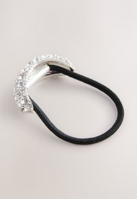 Schwarzes Haargummi mit silberfarbenem Metallakzent, verziert mit klaren Strasssteinen, geschwungenem Design und glatter Textur.