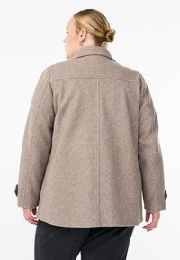 Brown wool coat with a structured collar, back vent, and two-button cuff details. Smooth texture with a fitted silhouette.