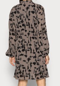 Brown and black patterned dress with long balloon sleeves, gathered at the waist, made from a lightweight fabric with soft texture.