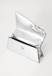 Hopea metallinen clutch, jossa on sileä pinta, taitettu muotoilu, napsautettava suljenta ja koristeellinen langansulkusomistus reunan ympärillä.