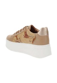 Zapatilla beige con parte superior de cuero suave que presenta un diseño de mapa, punta redonda, suela blanca ligeramente elevada y acento metálico en el talón.