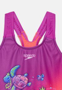 Maillot de bain violet avec un design dégradé présentant des tortues et des éléments aquatiques. Style dos nageur avec des accents orange vif et un tissu texturé.