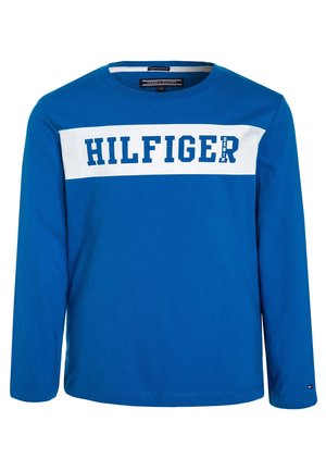 Blauwe lange mouwen shirt met een witte horizontale streep over de borst, "HILFIGER" tekst in het blauw en een klein "DENIM" label aan de rechterkant.