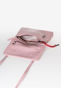 Borsa in pelle rosa con una superficie liscia, scomparti con cerniera e due spallacci sottili. Include dettagli in cerniera rossa e accenti circolari.