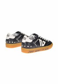 Sneaker in pelle bianca e nera con borchie metalliche, punta rotonda e suola in gomma. Presenta la scritta "PRONTO DA INDOSSARE" stampata sul lato.