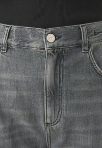 Denim jeans with a faded blue wash. Features a silver button at the waist, belt loops, and front pockets. Smooth texture, classic fit.