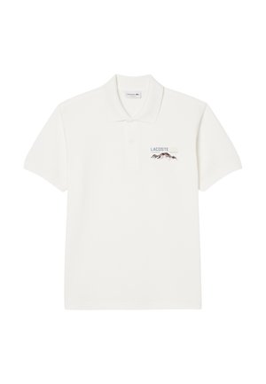 Polo shirt bianco in cotone, con colletto a tre bottoni, maniche corte e un design ricamato con "Lacoste" e montagne sul petto.