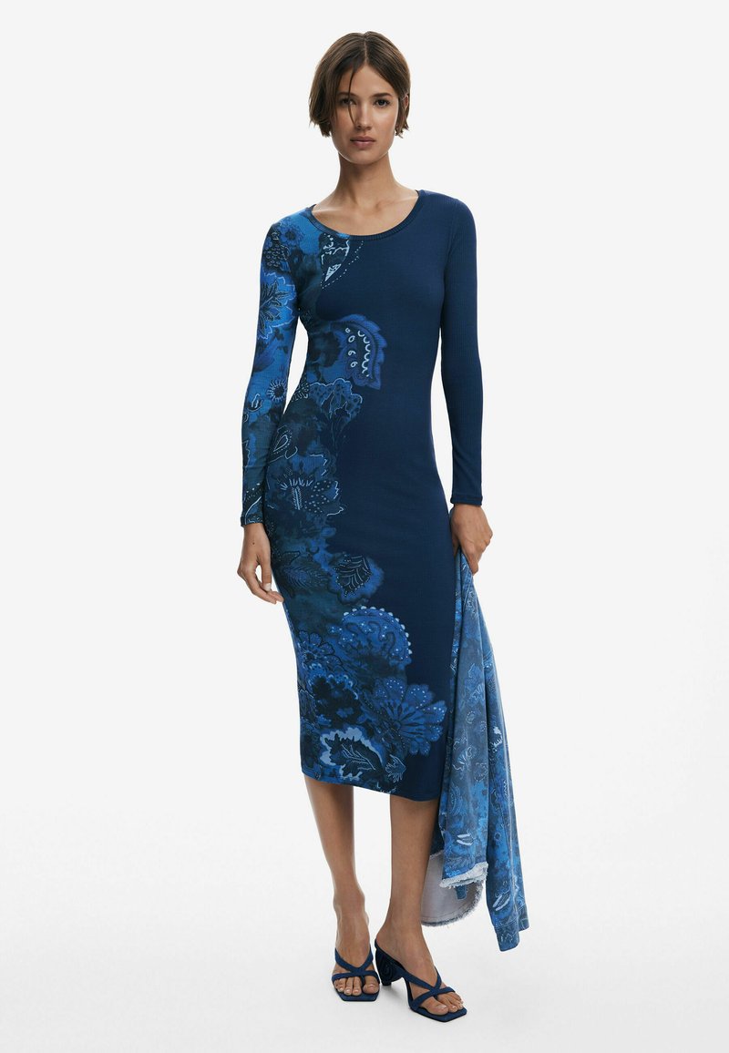 Nachtblaues, figurbetontes Kleid mit langen Ärmeln, das auf der linken Seite blaue Blumenmuster aufweist; beinhaltet einen passenden Schal, der an der Taille drapiert ist.